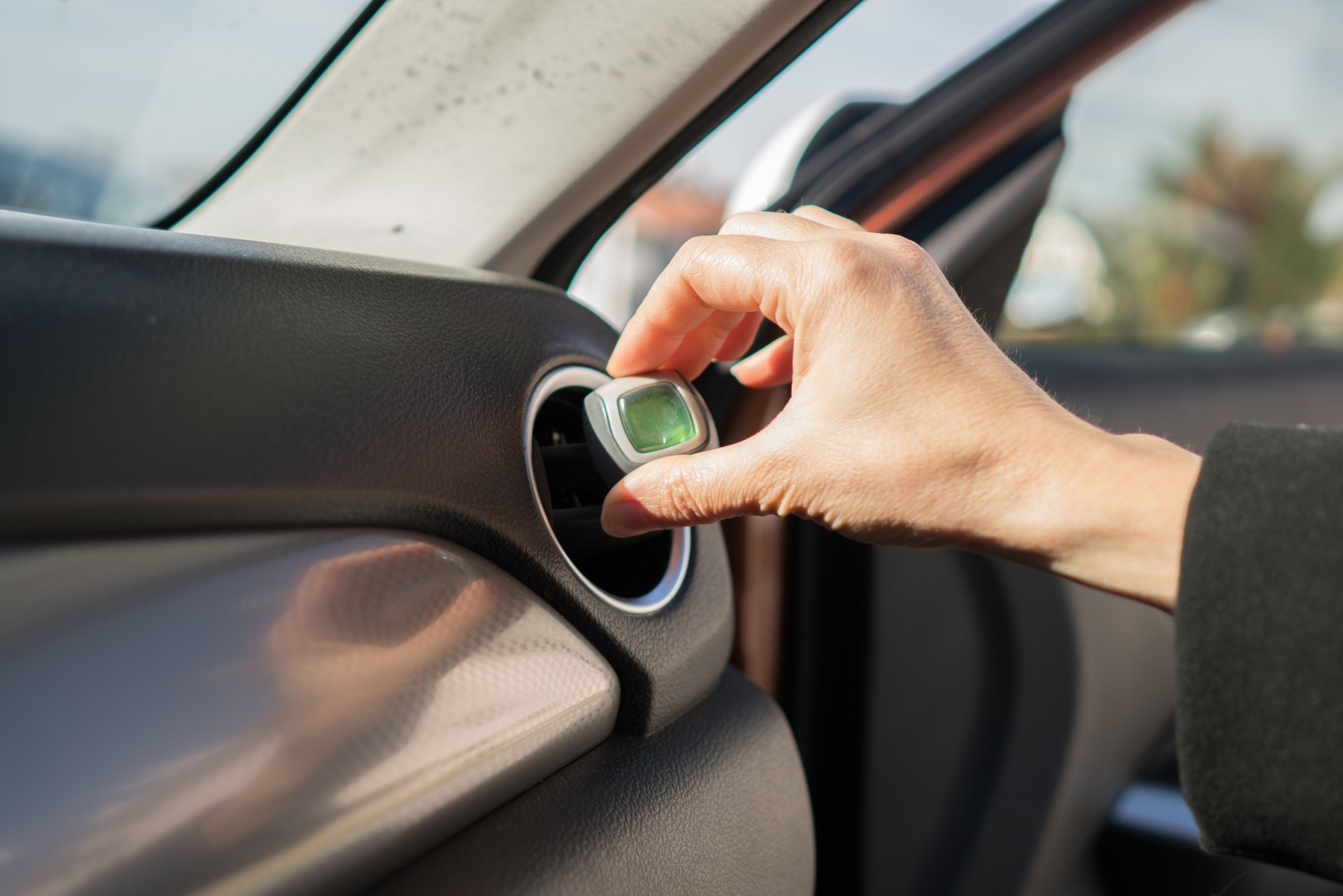 Car air freshener mounted to ventilation panel.